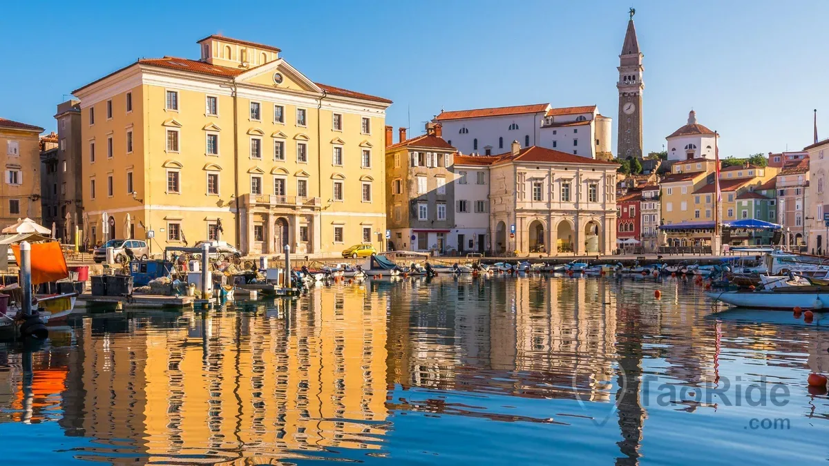 Piran waterfront with Venetian architecture and bell tower at sunset